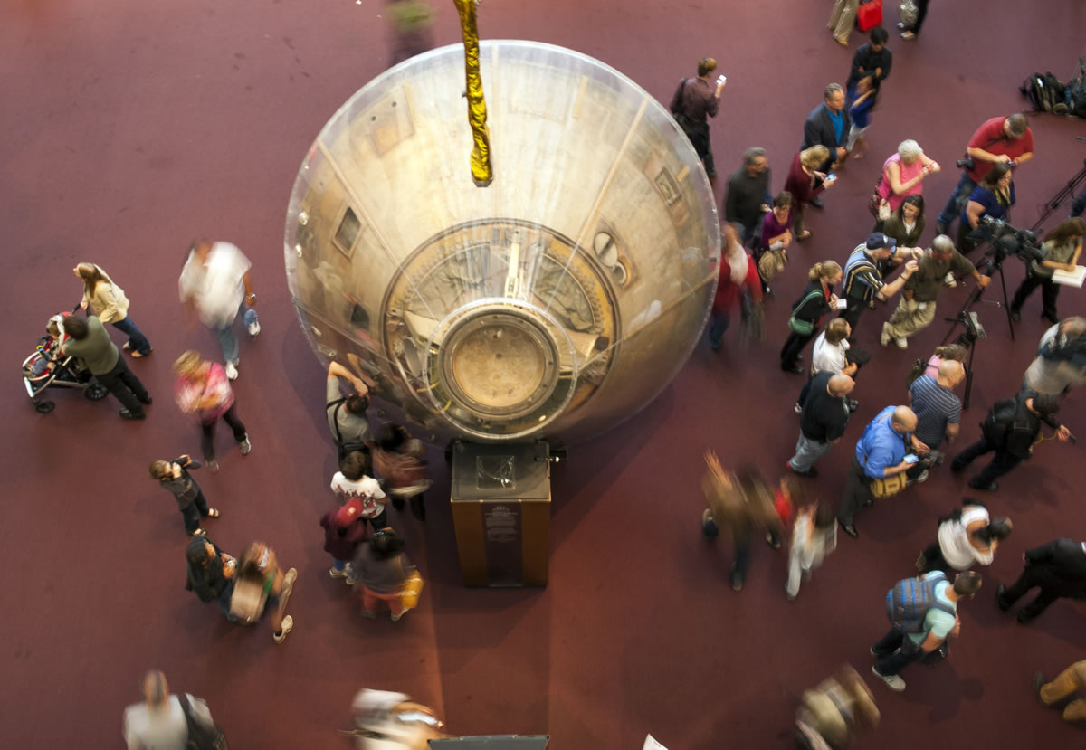 Visitors walk around the Apollo 11 capsule at the Smithsonian's Air and Space Museum after it opened on time, in Washington on Thursday.