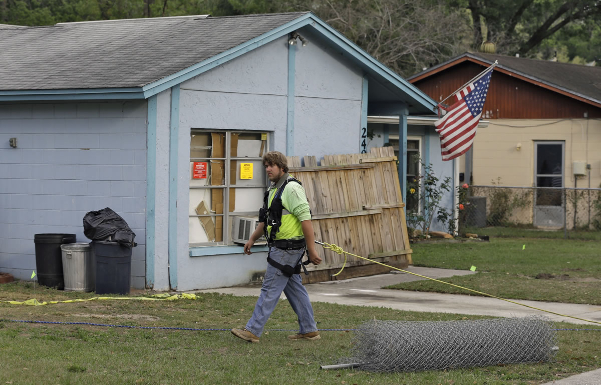 Chris O'Meara/Associated PressAn engineer, tethered with a safety line, walks in front of a home Saturday where a sinkhole opened up underneath a bedroom late Thursday evening and swallowed a man in Seffner, Fla. Jeffrey Bush, 37, was in his bedroom Thursday night when the earth opened and took him and everything else in his room. Five other people were in the house but managed to escape unharmed.