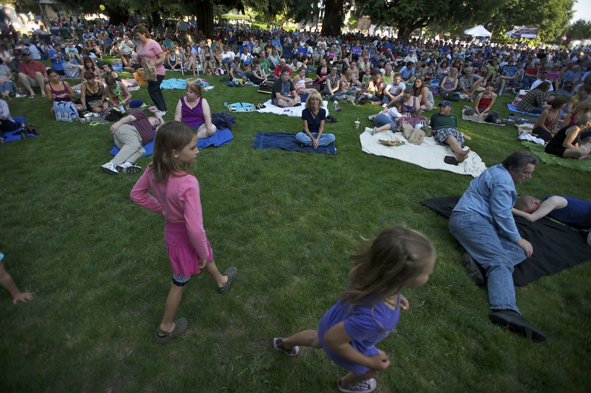 Amelia Wegner, 7, left in pink, walks off stage, along with 15-20 other children, after helping the Beatles tribute band Abbey Road with a rendition of Yellow Submarine during last year's Six to Sunset concert series kick off at Esther Short Park.