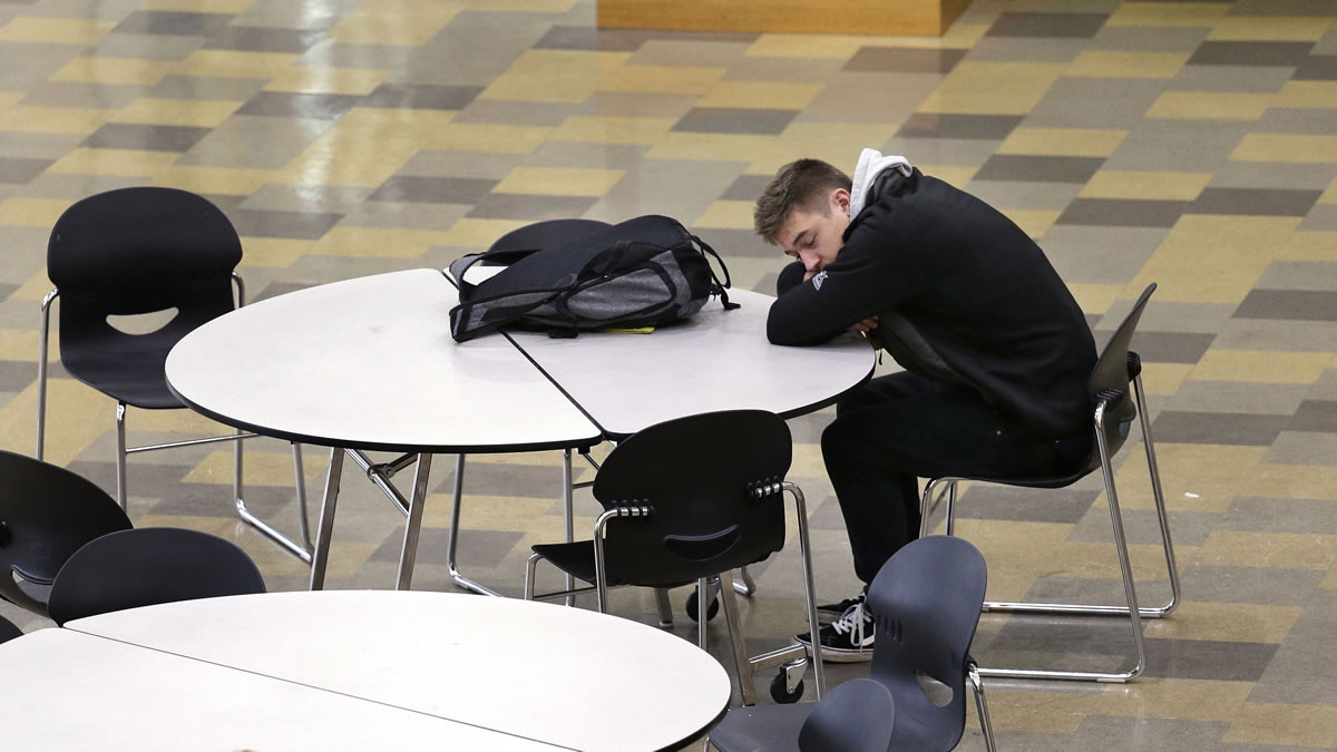 A student leans on a table in the cafeteria during first period at Roosevelt High School in Seattle. More school districts around the U.S. are heeding the advice of scientists who say teens shouldn&#039;t start school before 8 a.m.
