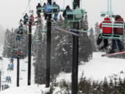 Skiers and snowboarders ride a chairlift at Stevens Pass, Wash.  on Nov. 20 2013.