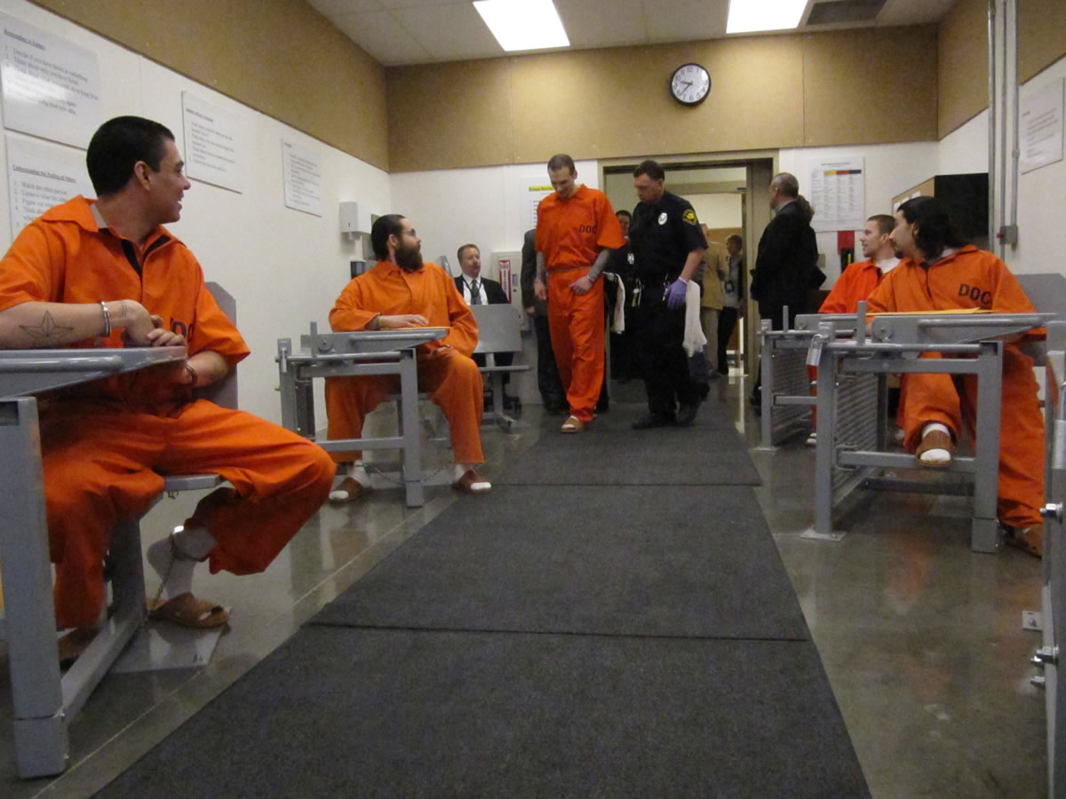 Several inmates look on as Donald Button is led by officers to his seat March 14 at the Washington State Penitentiary in Walla Walla.