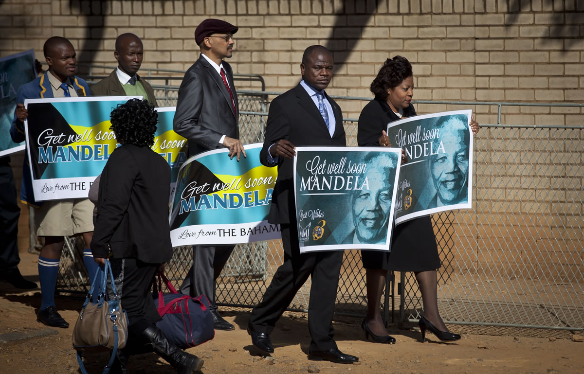 A group of wellwishers carrying get-well placards arrive at the Mediclinic Heart Hospital where former South African President Nelson Mandela is being treated in Pretoria, South Africa, on Sunday.