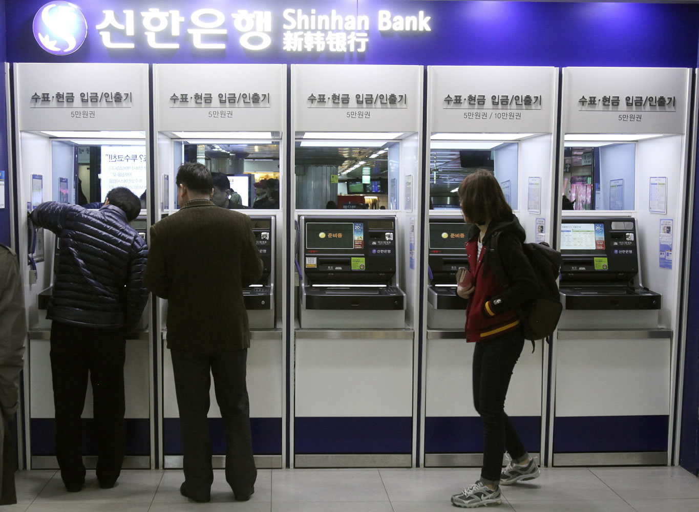 Depositors try to use automated teller machines at Shinhan Bank while the bank's computer networks are paralyzed at a subway station in Seoul, South Korea, on Wednesday.