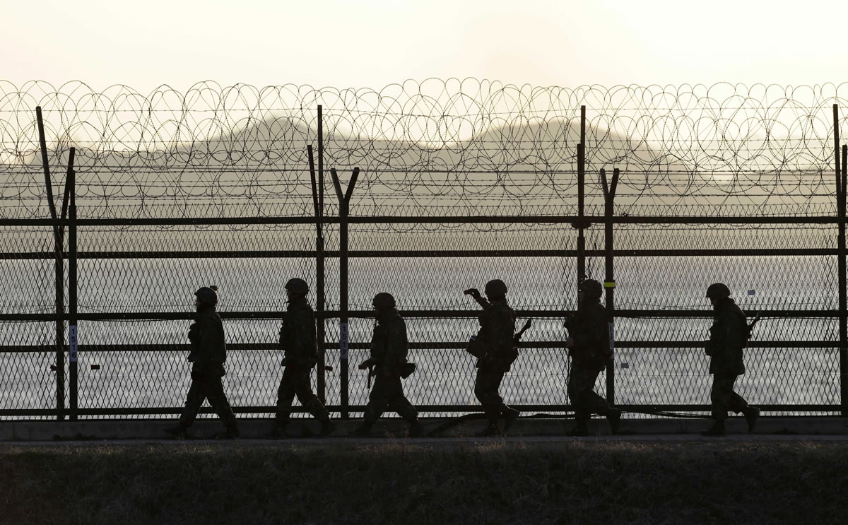 South Korean army soldiers patrol along a barbed-wire fence at sunset Sunday near the border village of Panmunjom, in Paju, north of Seoul, South Korea.