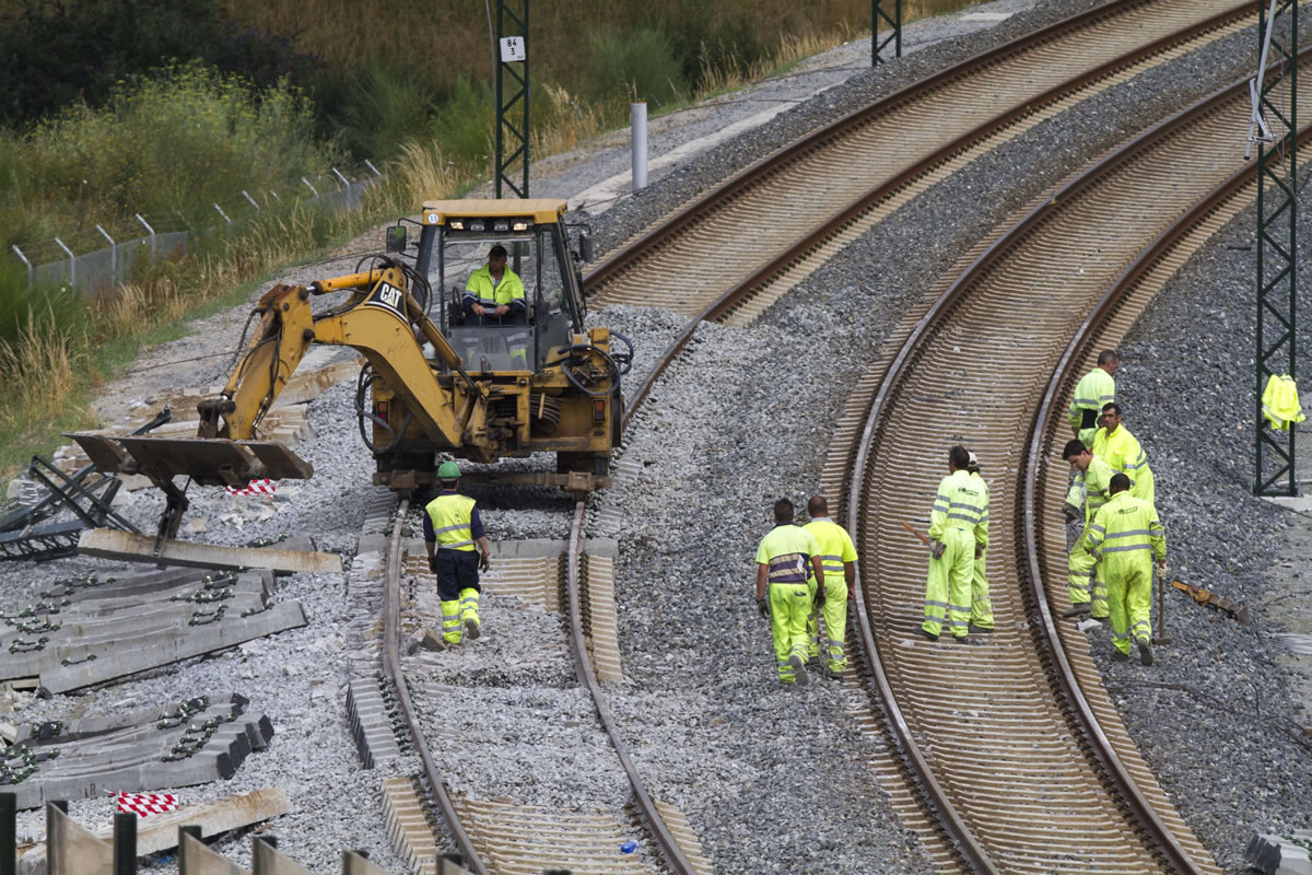 Rail personnel clear the area and fix the track at the site of a train accident in Santiago de Compostela, Spain, on Thursday.