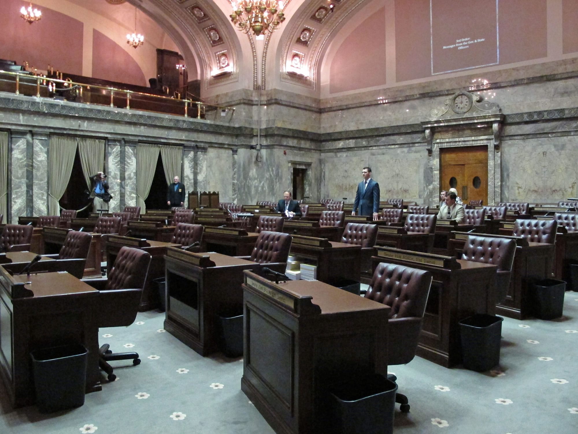 Republican Sen. Joe Fain stands in a mostly empty state Senate chamber after the official start of a special legislative session on Monday in Olympia .