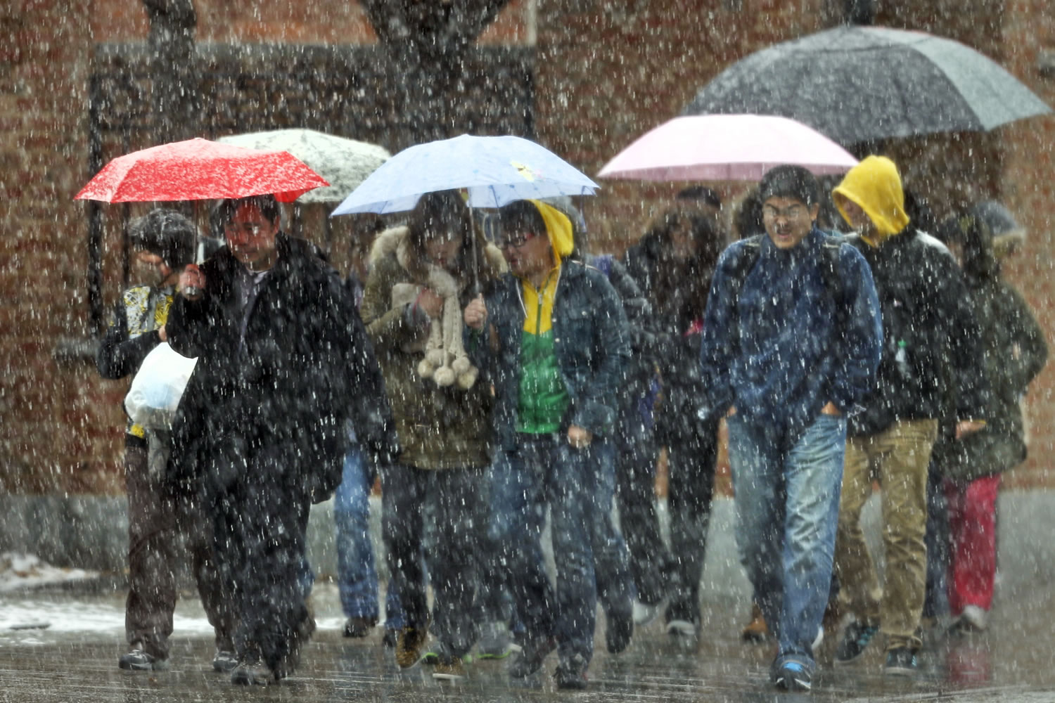Visitors to Independence National Historical Park walk during a spring snowstorm Monday in Philadelphia.
