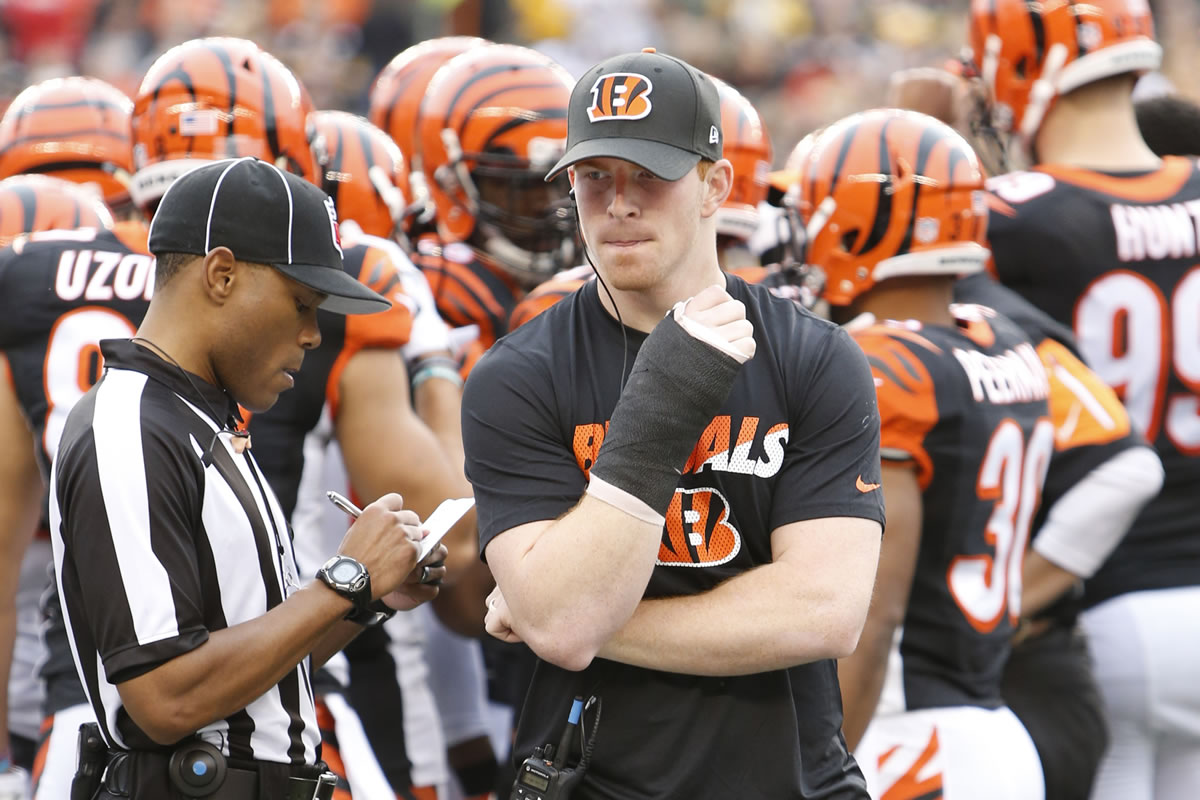 Cincinnati Bengals quarterback Andy Dalton walks the sidelines in a cast on his throwing hand after being taken out of the game with an injury in the first half of an NFL football game against the Pittsburgh Steelers, Sunday, Dec. 13, 2015, in Cincinnati.