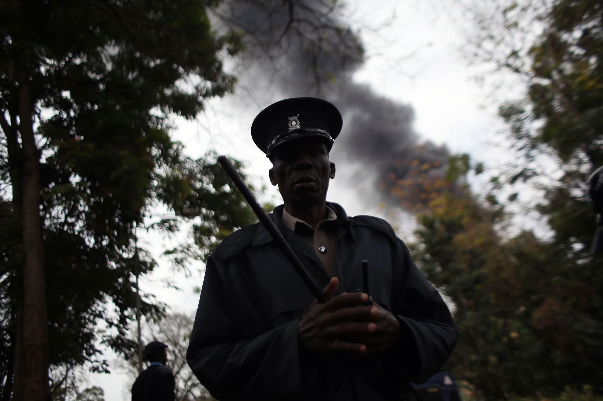 Files/Associated Press
A security officer stands guard as heavy smoke rises from the Westgate Mall in Nairobi, Kenya, on Monday, the third day of last weekend's siege.