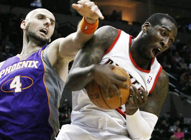 Portland Trail Blazers center J.J. Hickson, right, pulls in a rebound against Phoenix Suns center Marcin Gortat, from Poland, during the first quarter of an NBA basketball game in Portland, Ore., Saturday, Dec.