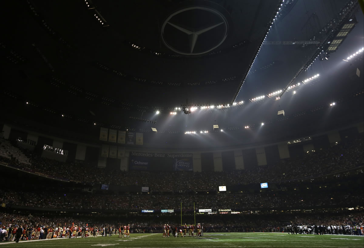 Players huddle on the field during a Superdome power outage in the second half of Super Bowl XLVII in New Orleans.