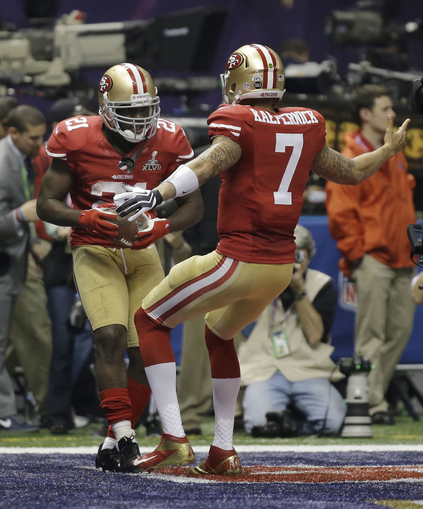 San Francisco 49ers quarterback Colin Kaepernick (7) and running back Frank Gore (21) celebrate a touchdown by Gore during the second half Sunday.