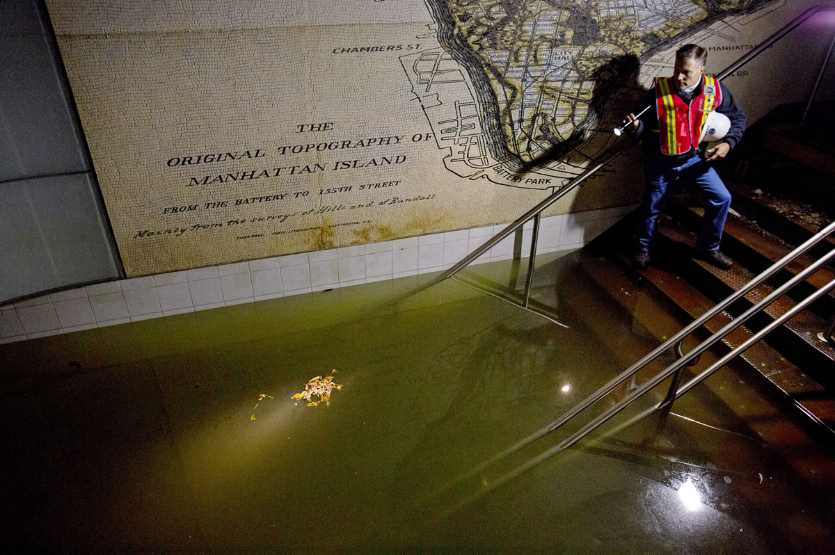 Joseph Leader, Metropolitan Transportation Authority vice president and chief maintenance officer, shines a flashlight on standing water inside the South Ferry 1 Train station in New York, showing flooding left in the wake of Superstorm Sandy on Nov.