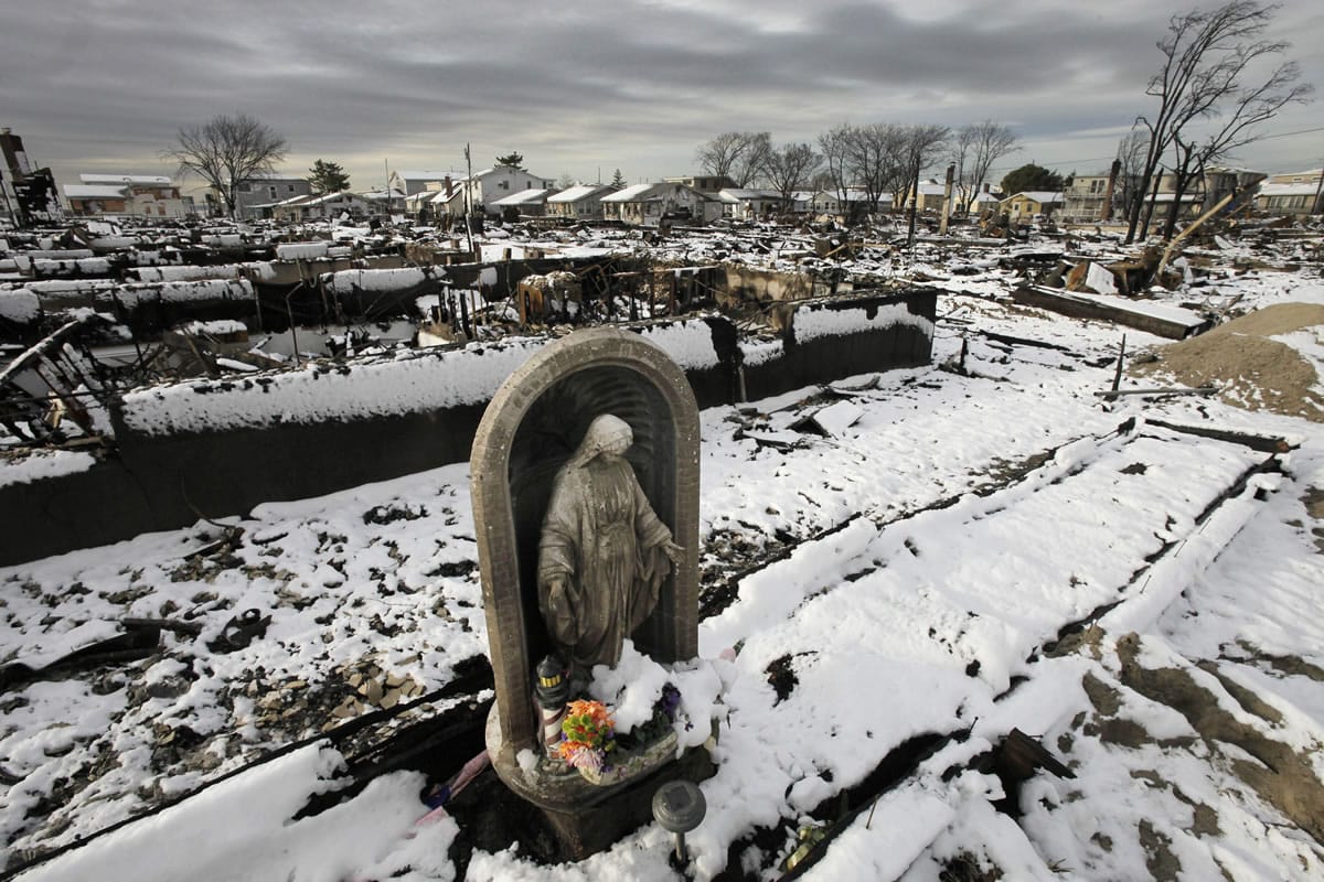 A religious statue stands in the fire-scorched landscape after a Nor'easter snow at Breezy Point in the Queens borough of New York on Nov.