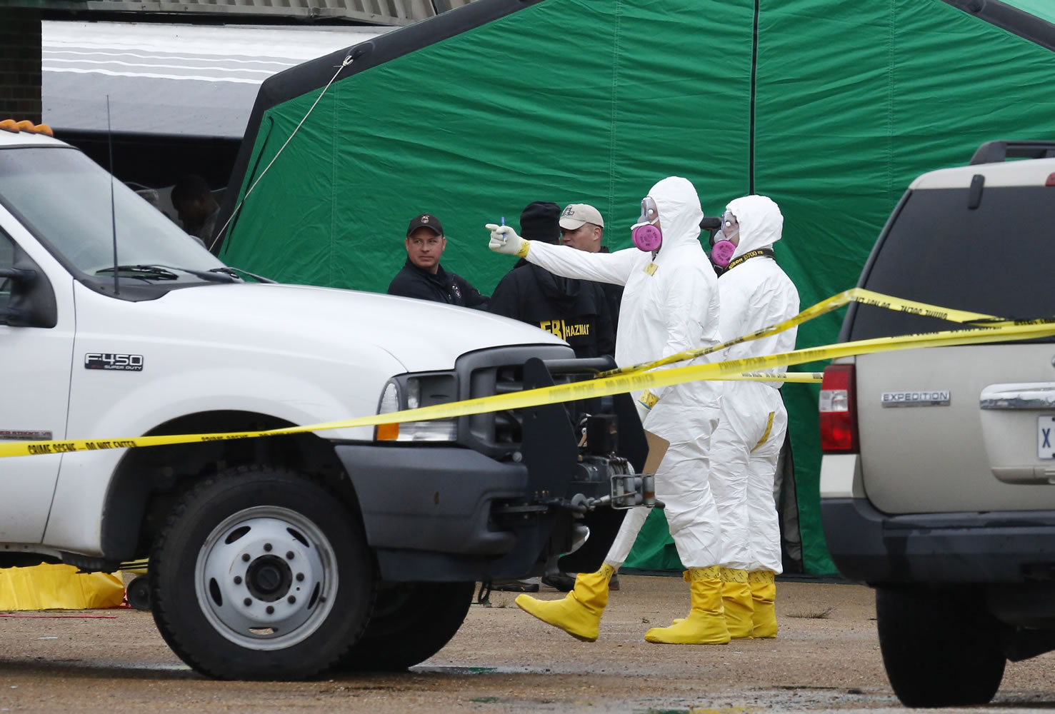 Federal authorities in hazmat suits stand outside a small retail space where neighboring business owners said Everett Dutschke used to operate a martial arts studio on Wednesday in Tupelo, Miss., in connection with the recent ricin attacks.