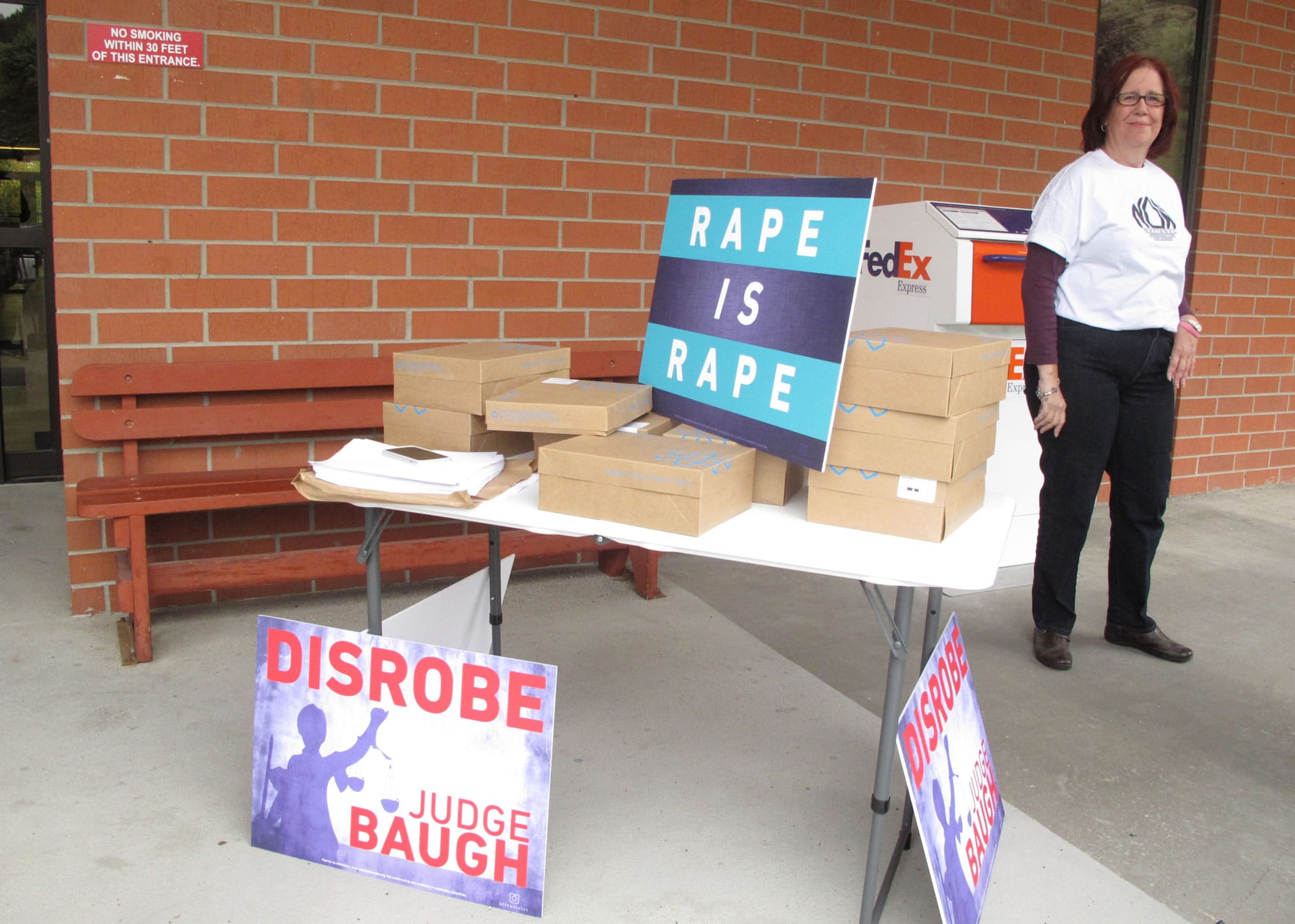 Marian Bradley with the National Organization for Women stands behind boxes containing 140,000 names and addresses of citizens who signed online petitions calling for the removal of Montana District Judge G. Todd Baugh on Tuesday in Helena, Mont.