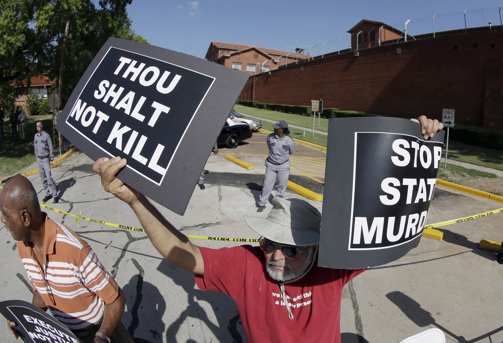 Habi Jawad holds up his signs to protest the execution of Kimberly McCarthy on Wednesday outside the Texas Department of Criminal Justice Huntsville Unit in Huntsville, Texas.