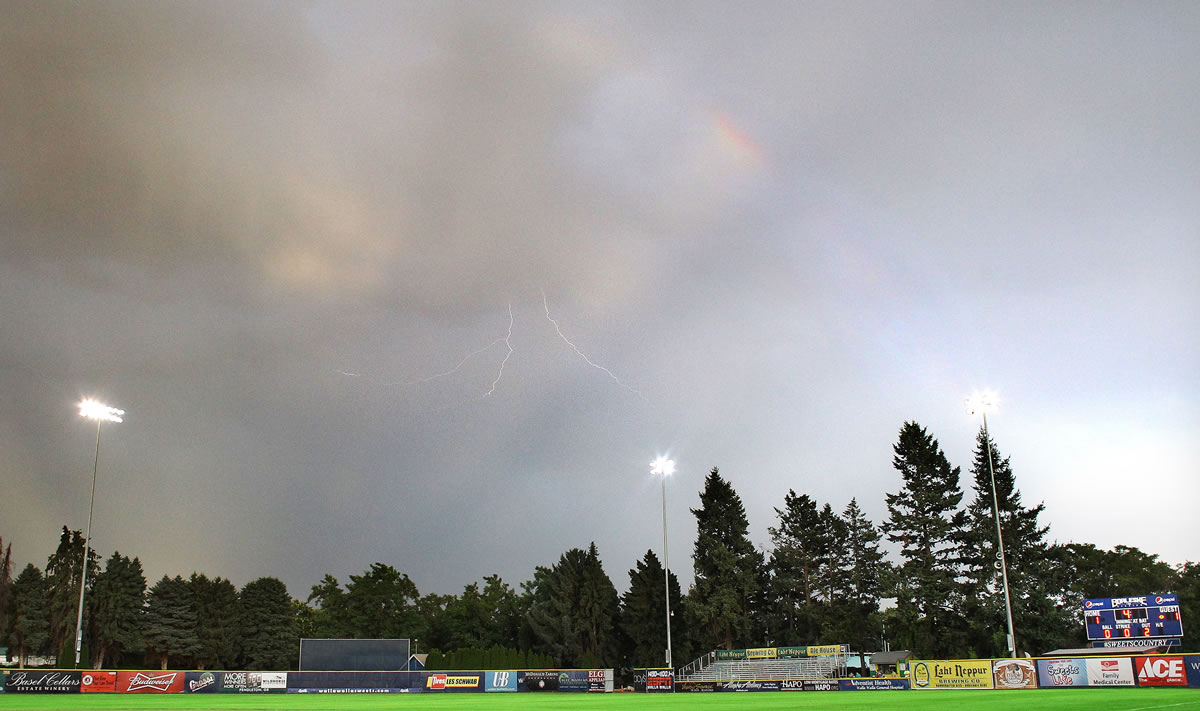 Jeff Horner/Walla Walla Union-Bulletin
A few fans remain next to the right field bleachers during a fourth-inning lightning and rainbow show Tuesday night at Borleske Stadium in Walla Walla.