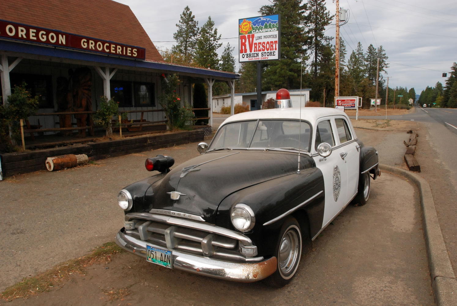 An old police car is permanently parked on the highway through O'Brien, Ore., where cuts to the sheriff's office have prompted some local residents to mount armed patrols to prevent crime.