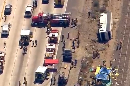 Rescue officials working the scene of an accident where a tour bus, right, crashed and turned over injuring multiple passengers Thursday in Los Angeles.