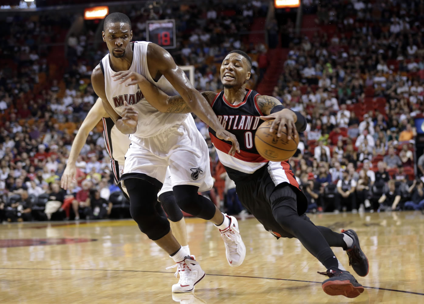 Portland Trail Blazers' Damian Lillard (0) is fouled by Miami Heat's Chris Bosh, left, in the first half of an NBA basketball game, Sunday, Dec. 20, 2015, in Miami.