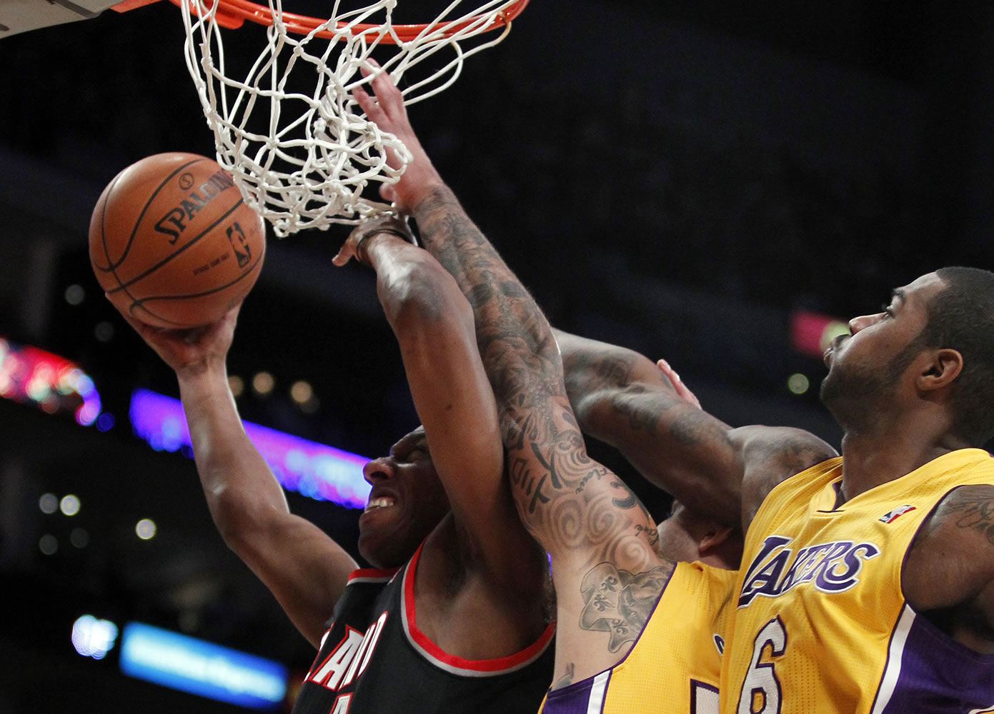 Portland Trail Blazers guard Nolan Smith, left, takes a shot against Los Angeles Lakers center Robert Sacre, middle, and forward Earl Clark (6) during the second half Friday.