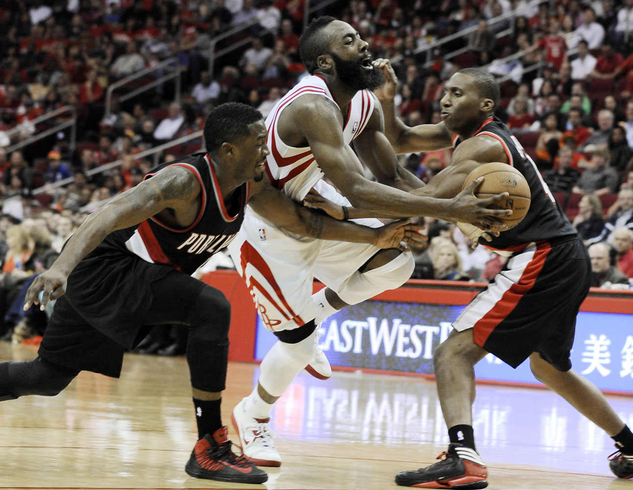 Houston's James Harden, center, is fouled by Portland Trail Blazers' Nolan Smith, right, as Wesley Matthews, left, reaches in in the second half Saturday.