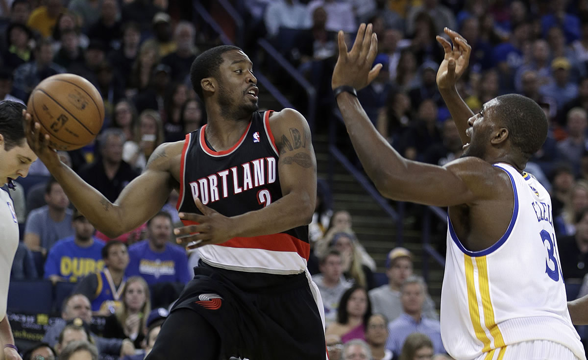 Portland Trail Blazers' Wesley Matthews, left, looks to pass away from Golden State Warriors' Festus Ezeli during the first half Saturday.