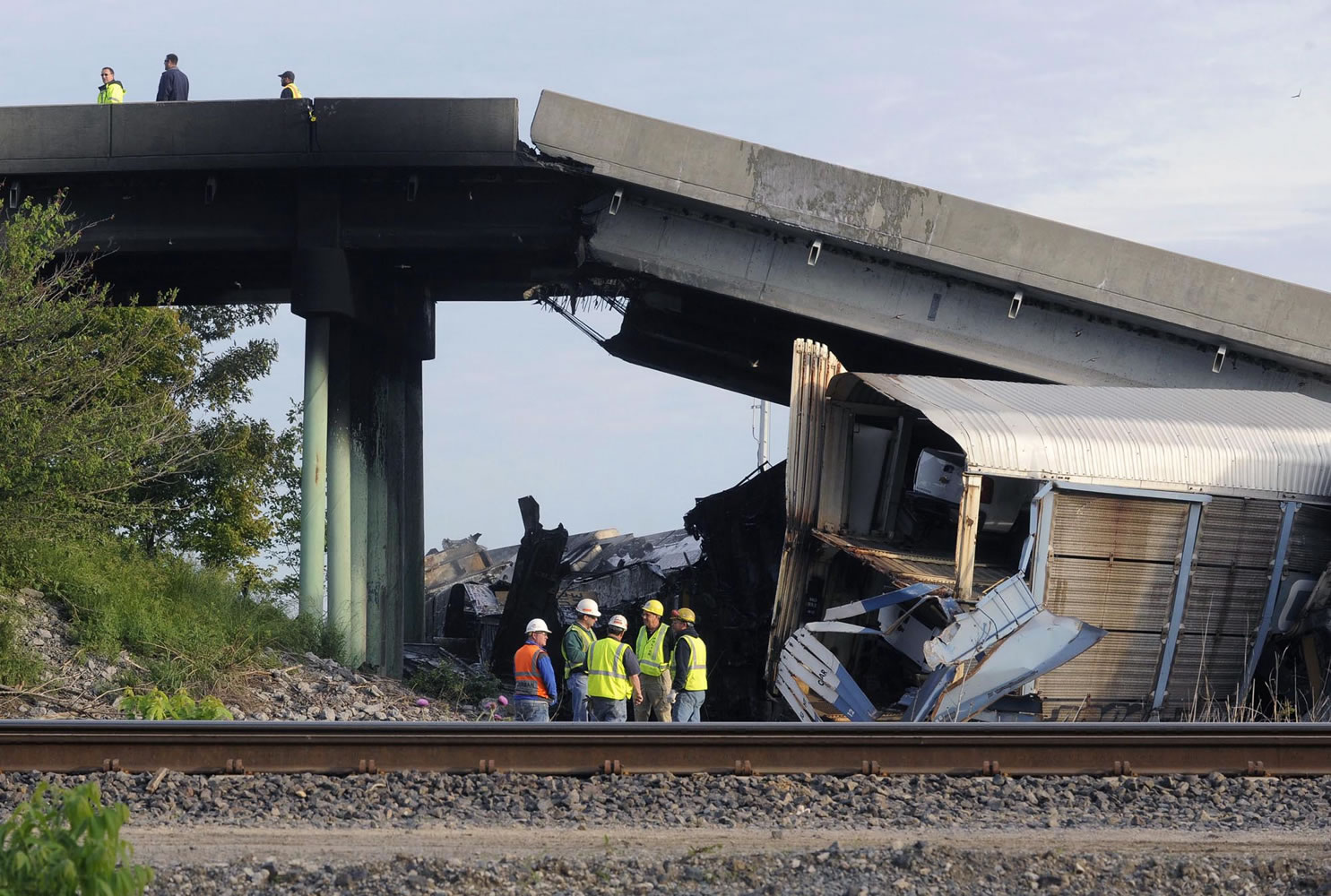 Emergency personnel investigate the Route M overpass at Rockview, Mo., about 10 miles south of Cape Girardeau, after it collapsed onto the railroad tracks Saturday.