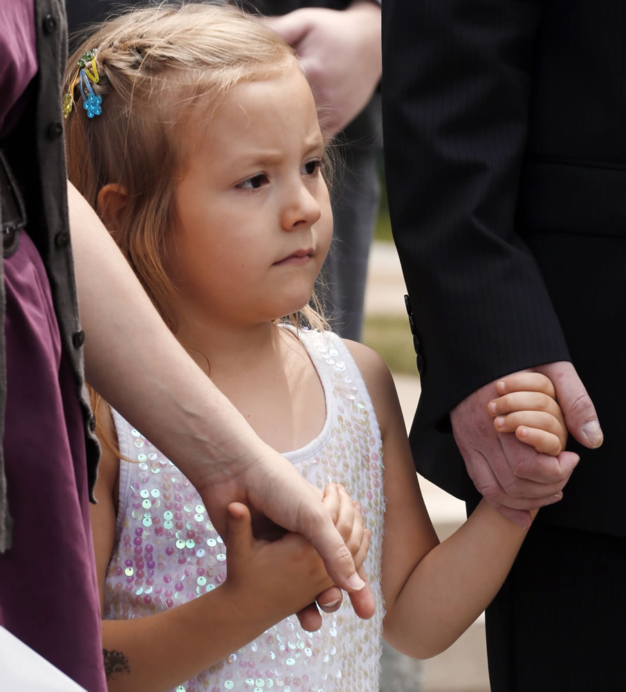 Six-year-old transgender girl Coy Mathis holds hands with her attorney Michael Silverman and her mother Kathryn Mathis at a news conference at the Capitol in Denver on Monday.