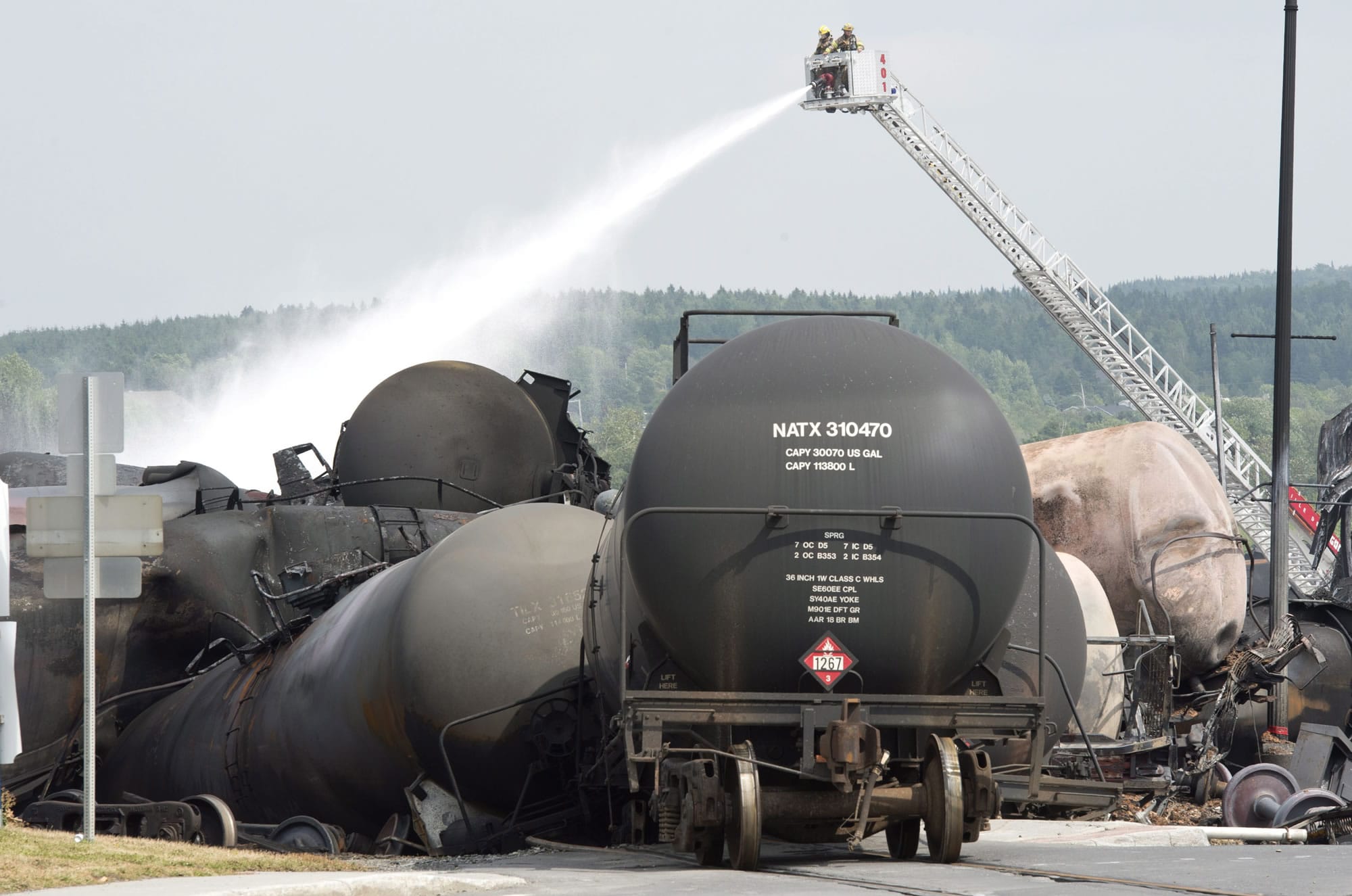 Firefighters water railway cars the day after a train derailed causing explosions of railway cars carrying crude oil in Lac Megantic, Quebec, on July 7.