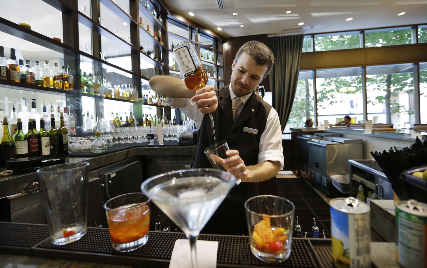 Bartender Derek Simoes mixes drinks July 3 in the newly redesigned bar at a Sheraton hotel in Seattle.