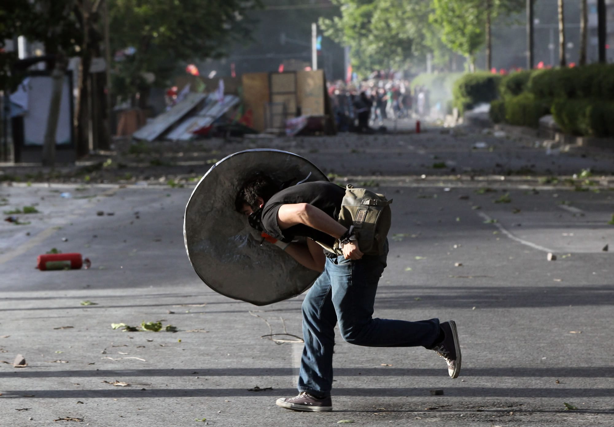 A protester takes cover during clashes with security forces in Ankara, Turkey, on Sunday.