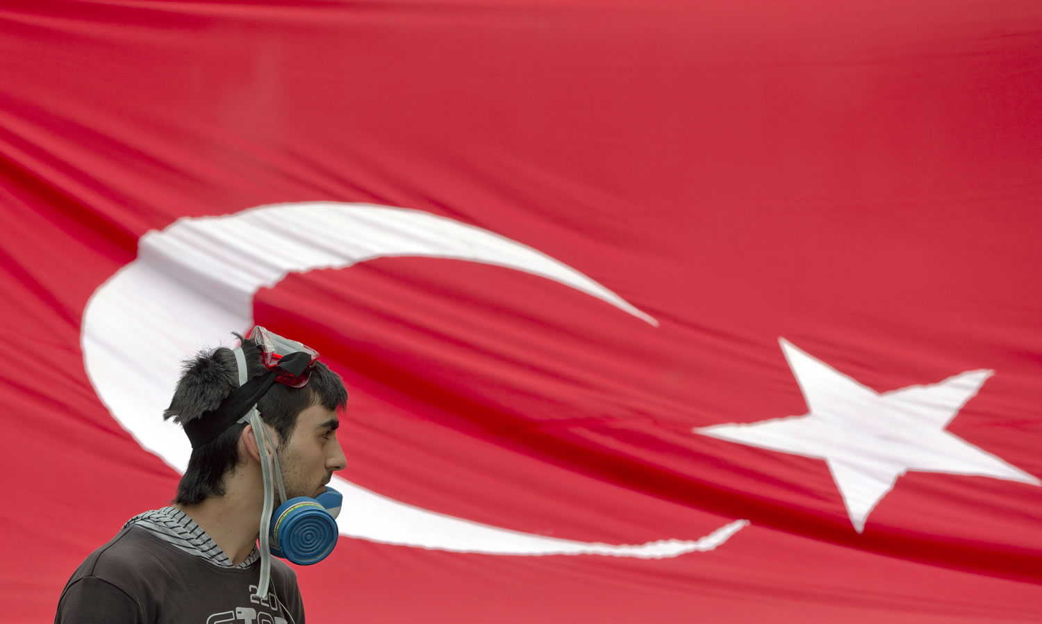 A protester with a gas mask stands in front of a Turkish flag near a barricade on the edge of Gezi Park on Wednesday in Istanbul, Turkey.