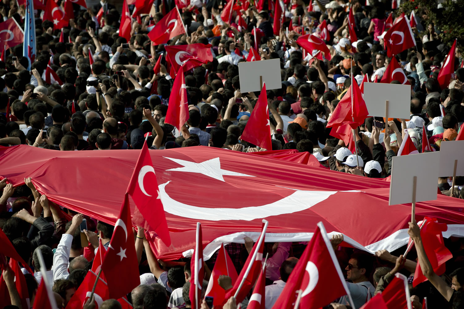 Supporters of Turkish Prime Minister Recep Tayyip Erdogan carry a large Turkish flag Sunday during his speech in Ankara, Turkey.