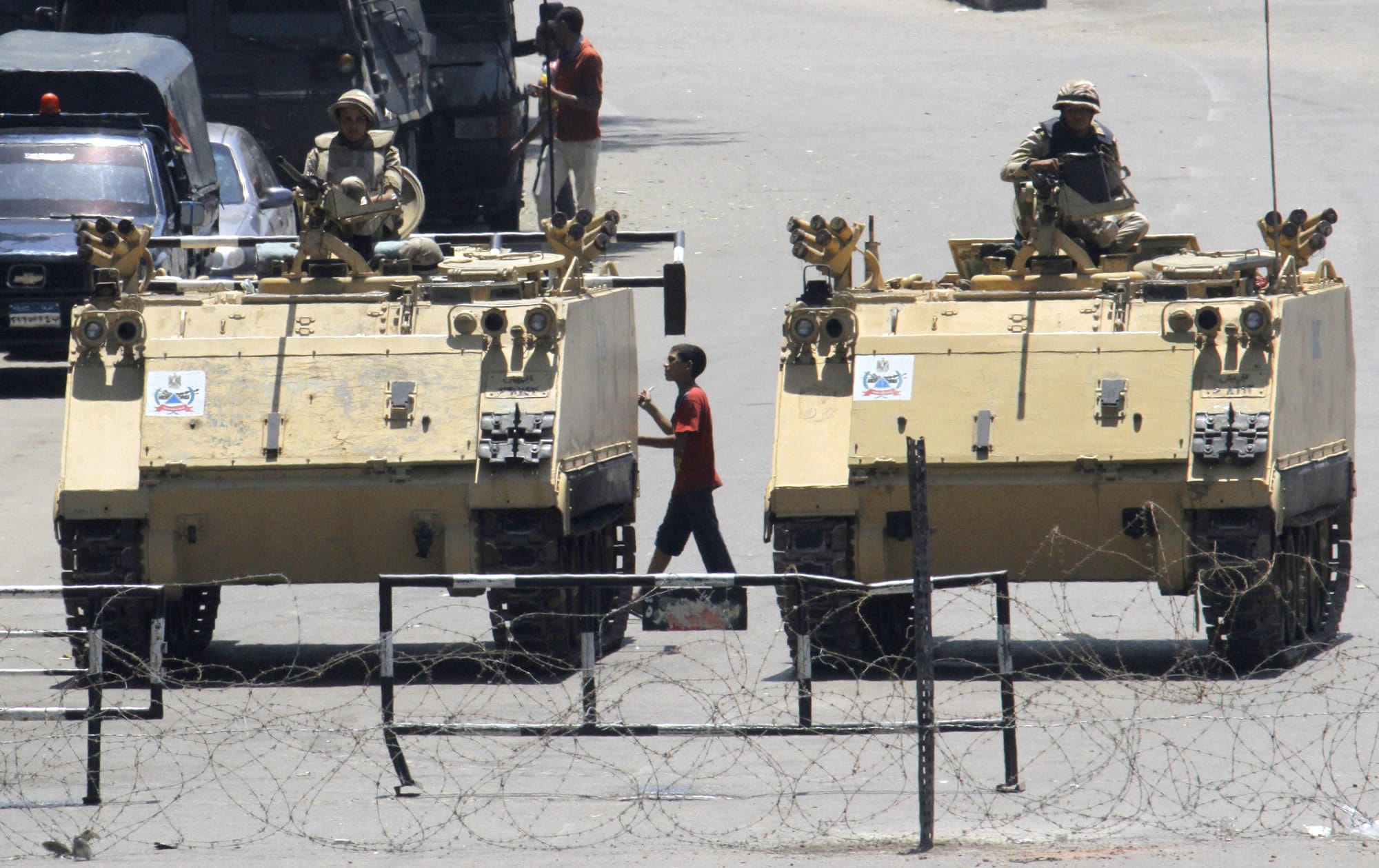 An Egyptian walks between armored vehicles blocking Tahrir Square in Cairo, Egypt, last month.