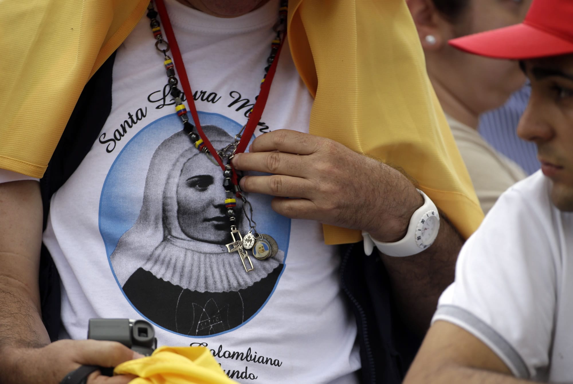 A member of the crowd wearing a shirt with a portrait of Laura di Santa Caterina da Siena Montoya of Colombia waits for the arrival of Pope Francis for a canonization Mass in St.