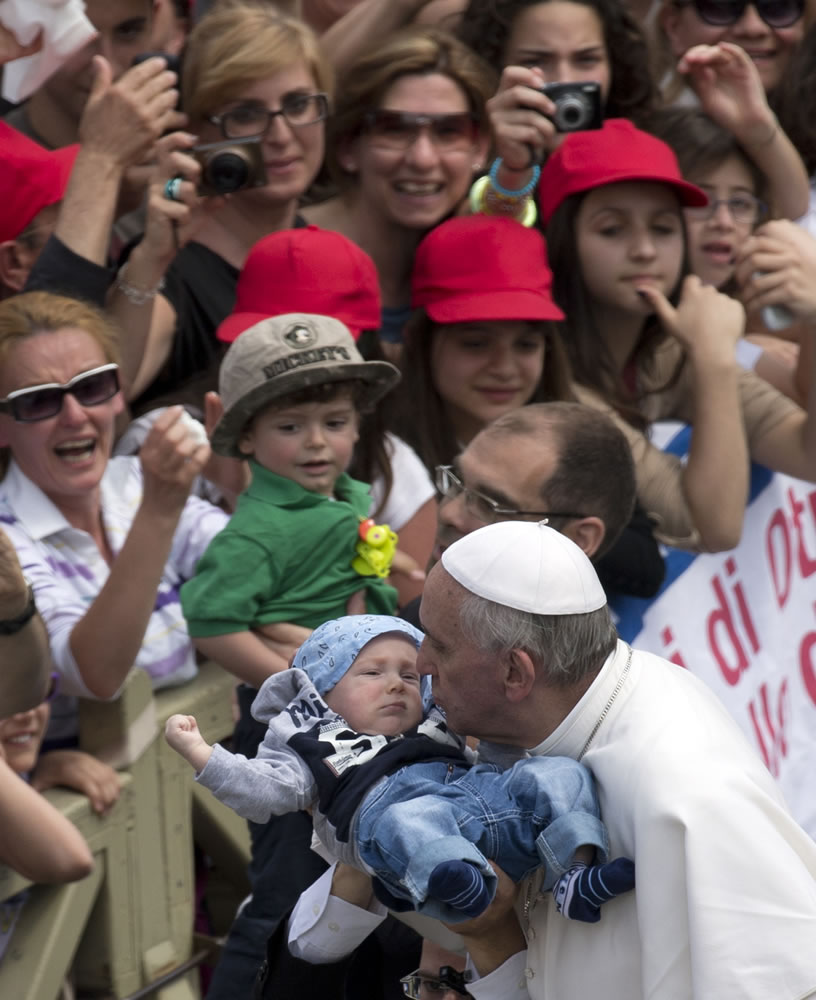 Pope Francis kisses a baby after a canonization ceremony in St.
