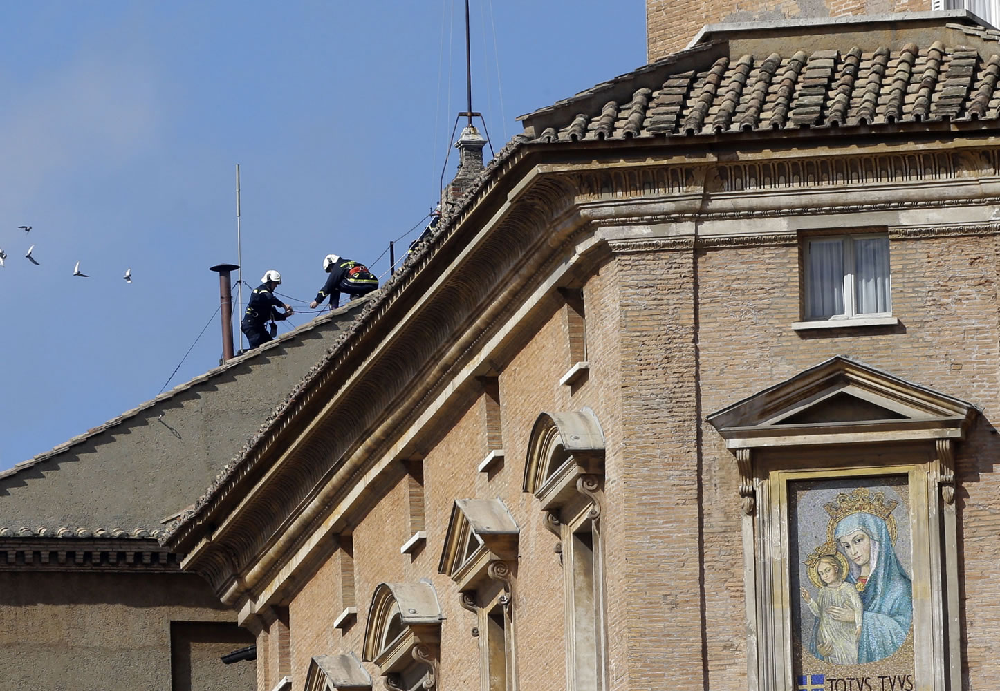 Firefighters place the chimney on the roof of the Sistine Chapel, where cardinals will gather to elect the new pope, at the Vatican, on Saturday.