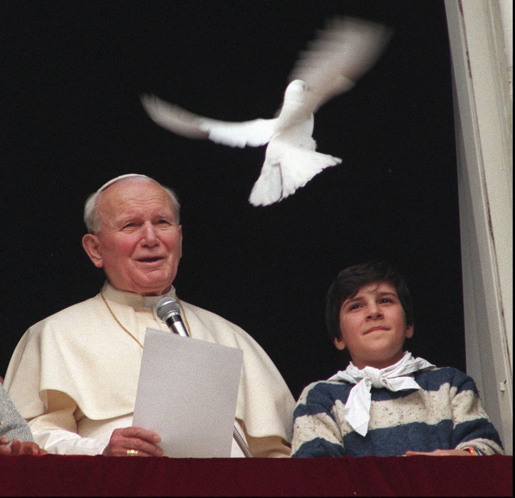 Pope John Paul II looks at a dove after he delivered the noon blessing from the window of his studio overlooking St. Peter's Square at the Vatican on Jan.