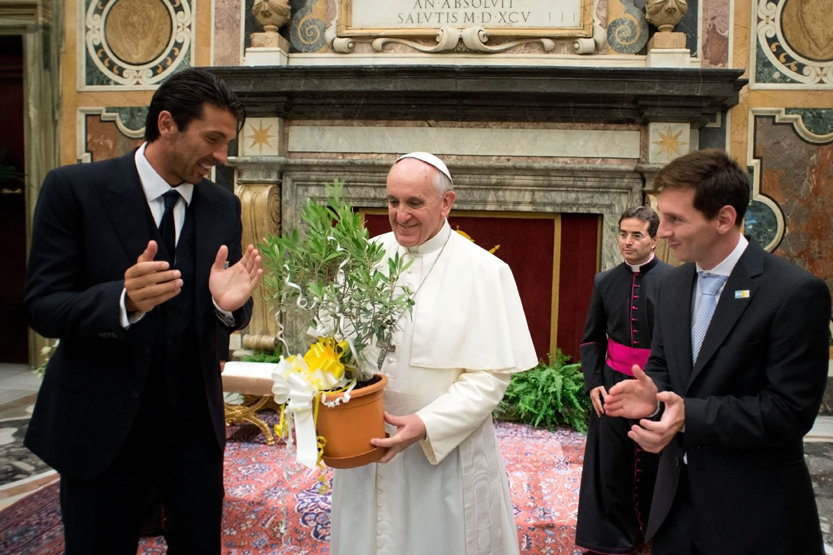 Pope Francis is applauded by Italy goalie Gianluigi Buffon, left, and Argentine soccer star Lionel Messi during a private audience at the Vatican on Tuesday.
