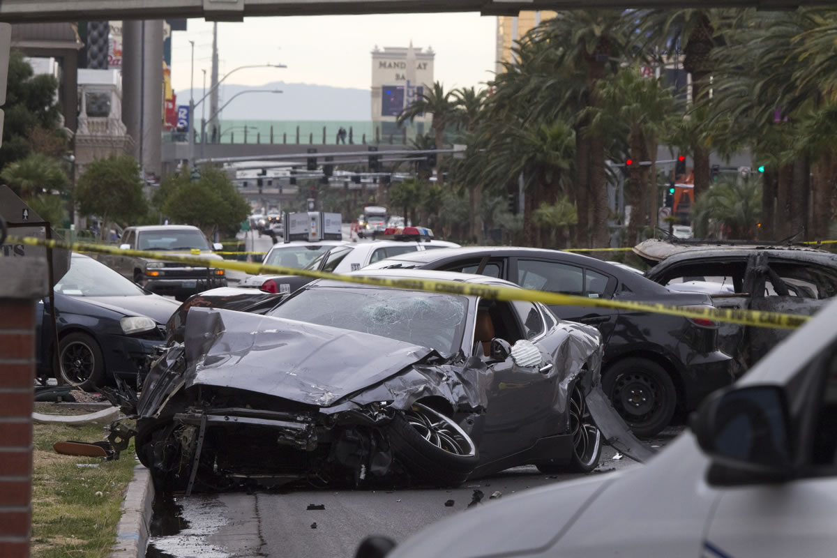 Police rope off the scene of  a shooting and multicar accident on the Las Vegas Strip in Las Vegas early Thursday. Authorities say at least one person in a Range Rover shot at people in a Maserati that then crashed into a taxi cab. The taxi cab burst into flames, and the driver and passenger were killed.