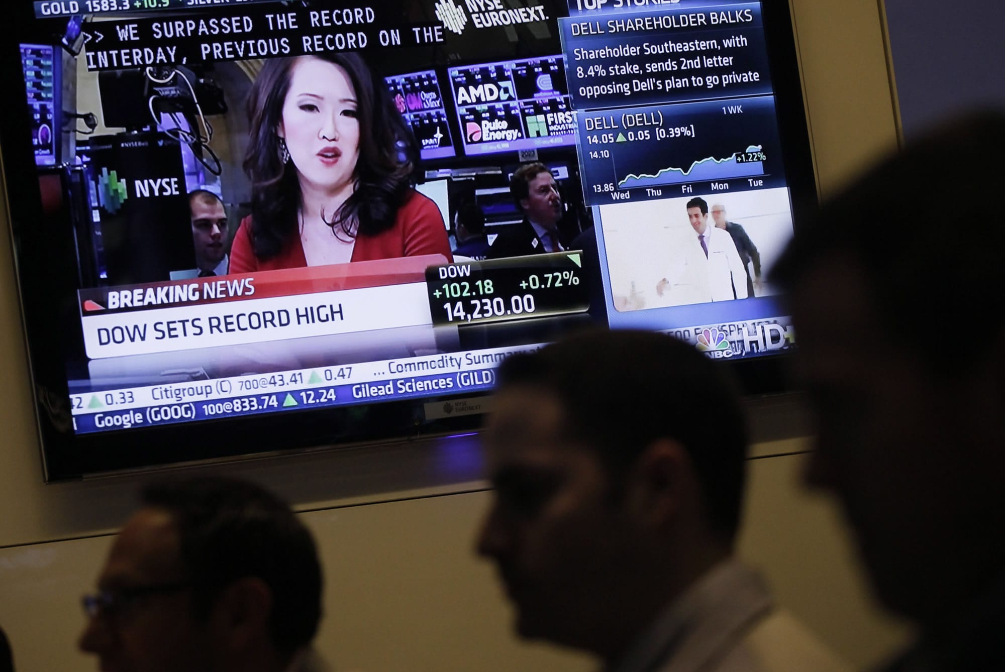 Stock traders work at the New York Stock Exchange as a television screen carries financial news on Tuesday in New York.