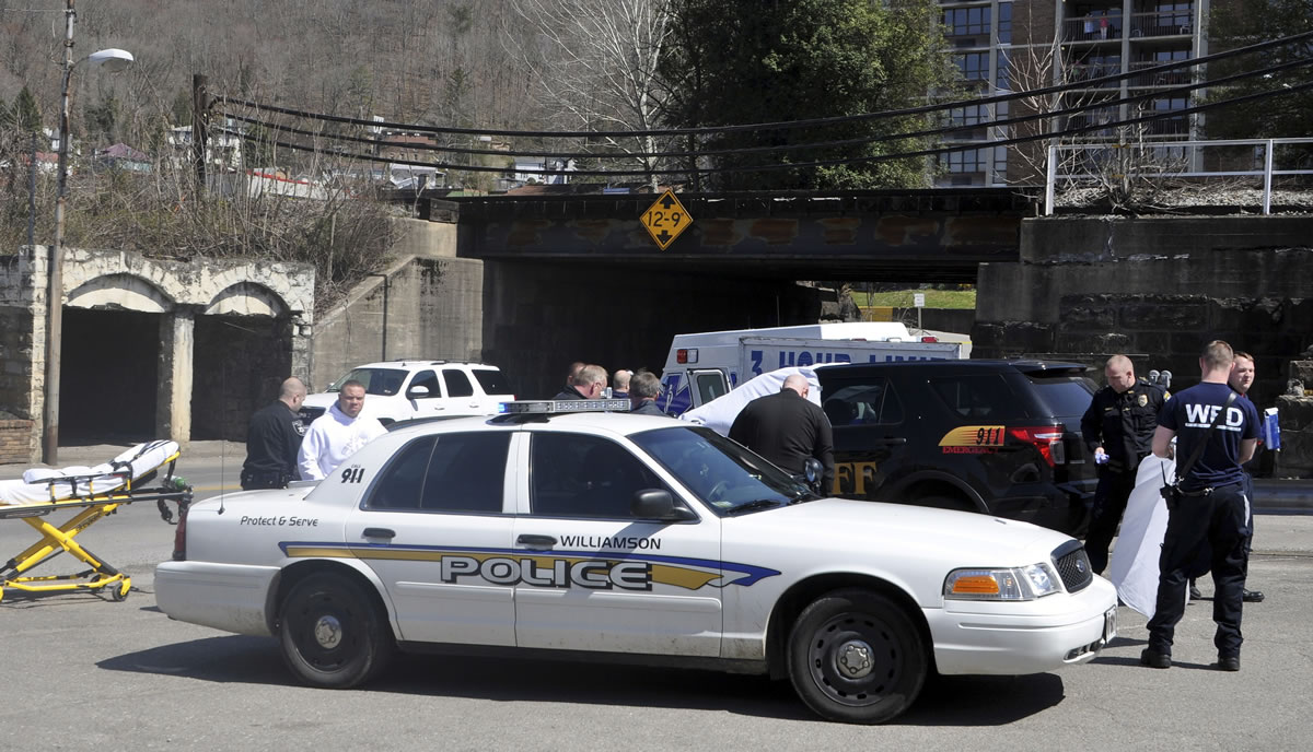 Law enforcement officers and emergency service personnel converge on the scene of the shooting in downtown Williamson, W.Va., on Wednesday, where Sheriff Eugene Crum was shot and killed at point blank range.