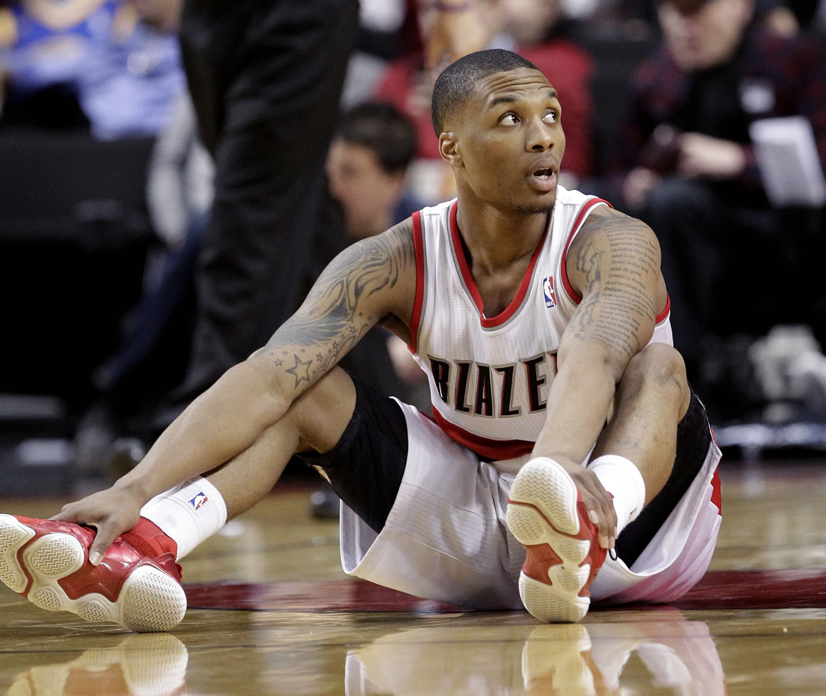 Don Ryan/The Associated Press
Portland Trail Blazers guard Damian Lillard sits on the floor after losing the ball during the second half of an basketball game  against the Golden.