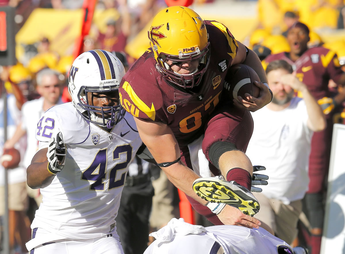 Arizona State tight end Chris Coyle leaps for extra yards as Washington linebacker Cory Littleton (42) defends during the first half of an NCAA college football game, Saturday, Oct. 19, 2013, in Tempe, Ariz.