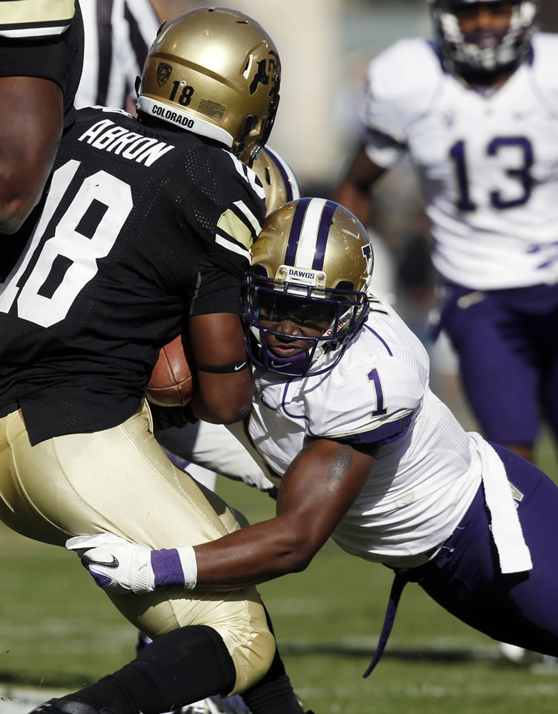 Washington's Sean Parker, right, stops Colorado punt returner Donta Abron in the second quarter of the Huskies' win on Saturday.