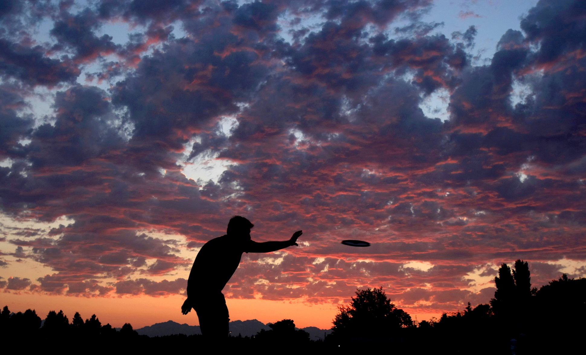 Colin Potter of Bremerton reaches out to catch a flying disc during an orange sunset last week.