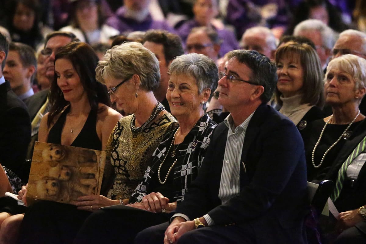 Carol James, center, surrounded by her children, Jeni Simmons, left, Jill Woodruff, and Jeff James, right, smile during remembrances of former University of Washington football coach Don James at his memorial service at Alaska Airlines Arena (HecEd Pavilion) in Seattle, Sunday Oct. 27, 2013. James passed away a week ago of pancreatic cancer at age 80.